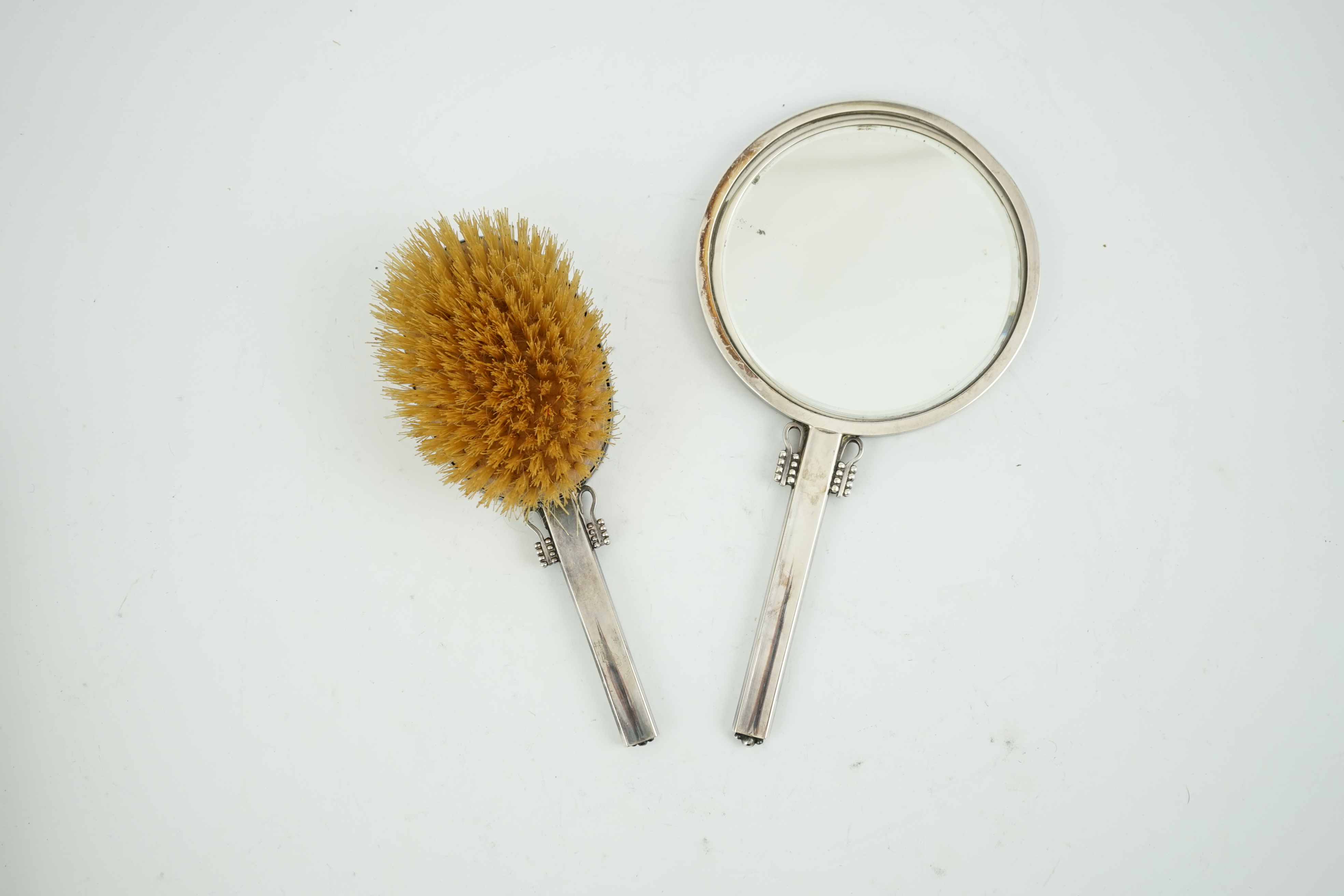 A 1950's Harald Nielson for Georg Jensen silver mounted hand mirror and matching hair brush